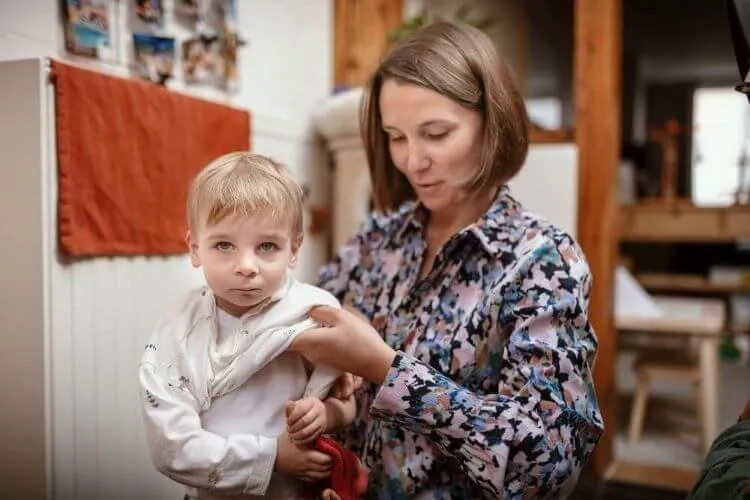 Mama kleedt haar kindje aan