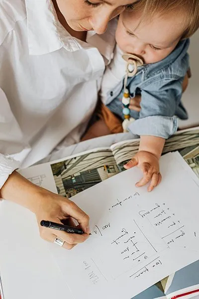 Vrouw maakt planning op met kind in haar arm
