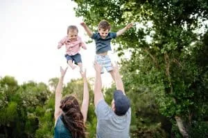 Deeltijds werkende ouders gooien twee kinderen in de lucht myfamily