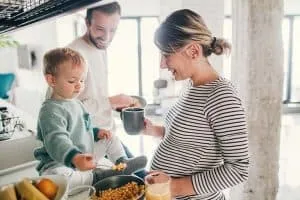 zwangere mama kookt thuis met man en kind