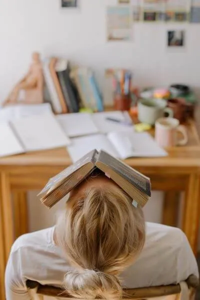 Student met boek op aangezicht