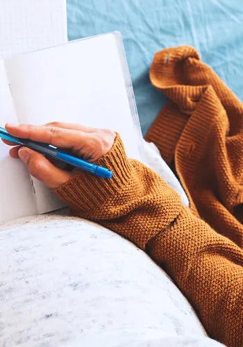 MyFamily zelfstandige zwangere vrouw, schrijvend in schriftje